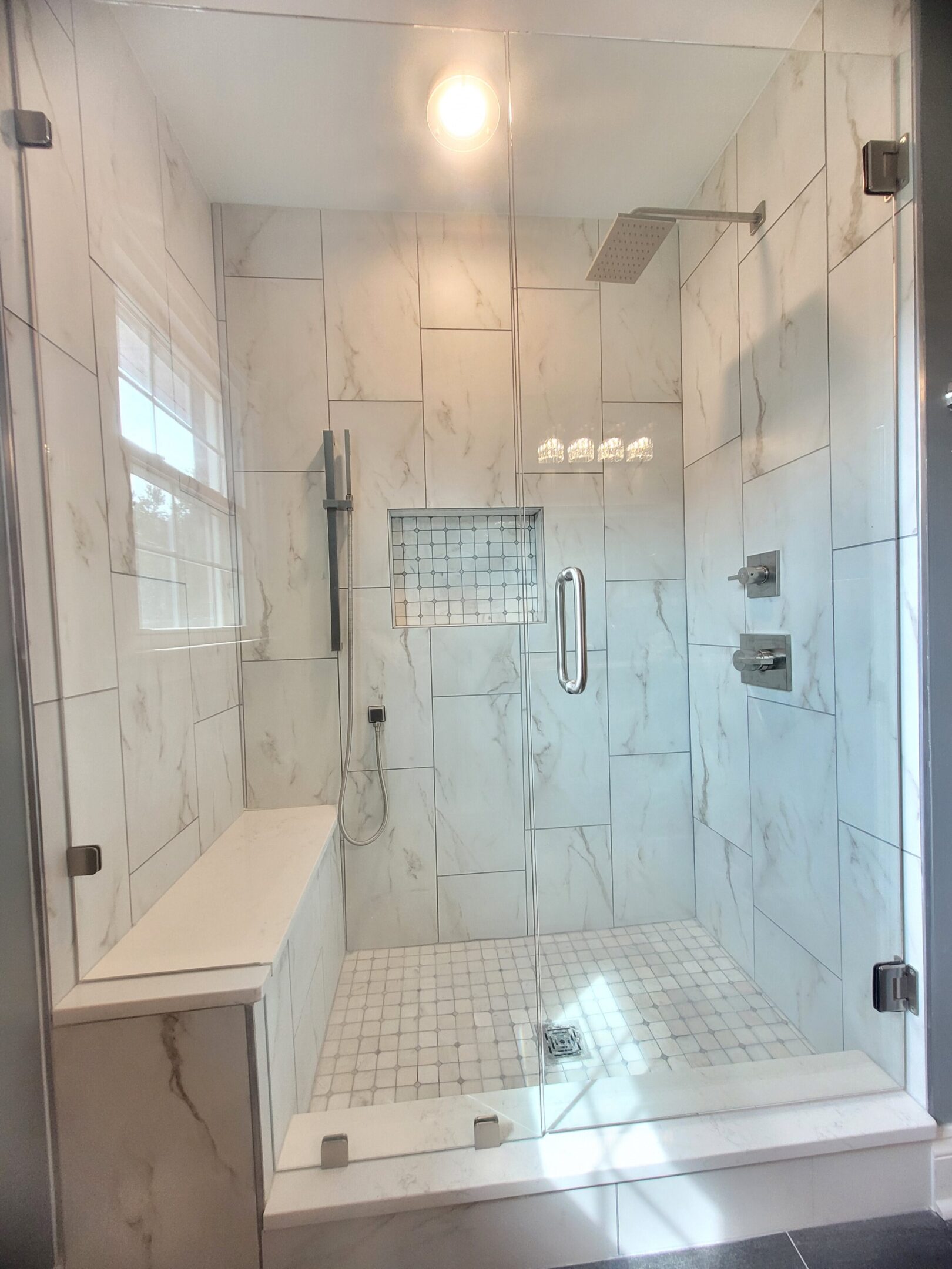 A large walk in shower with tiled walls and floor.