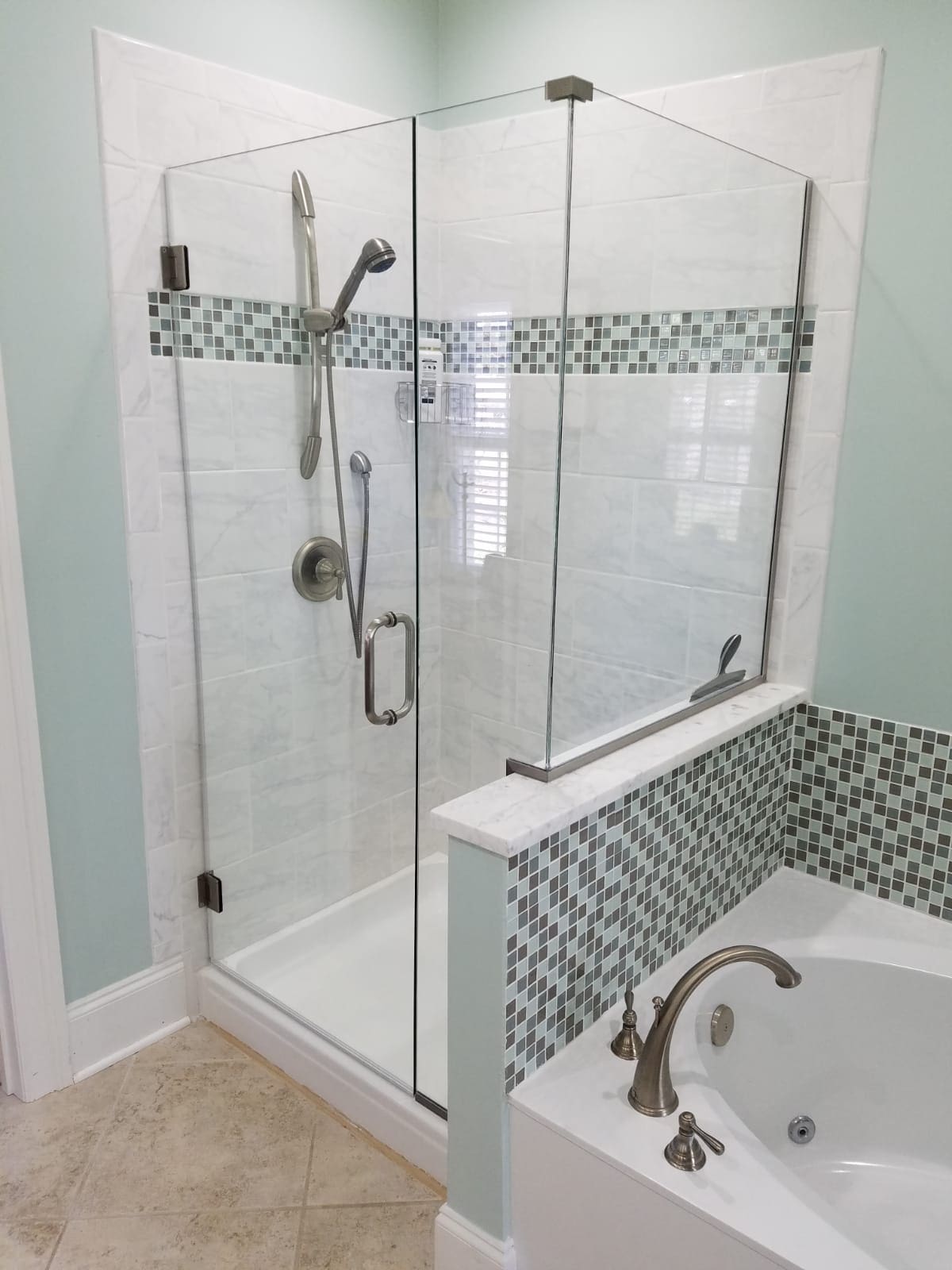 A bathroom with a tub, shower and tiled walls.