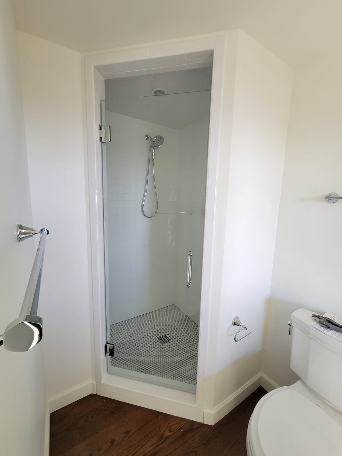 A bathroom with a toilet and shower stall.