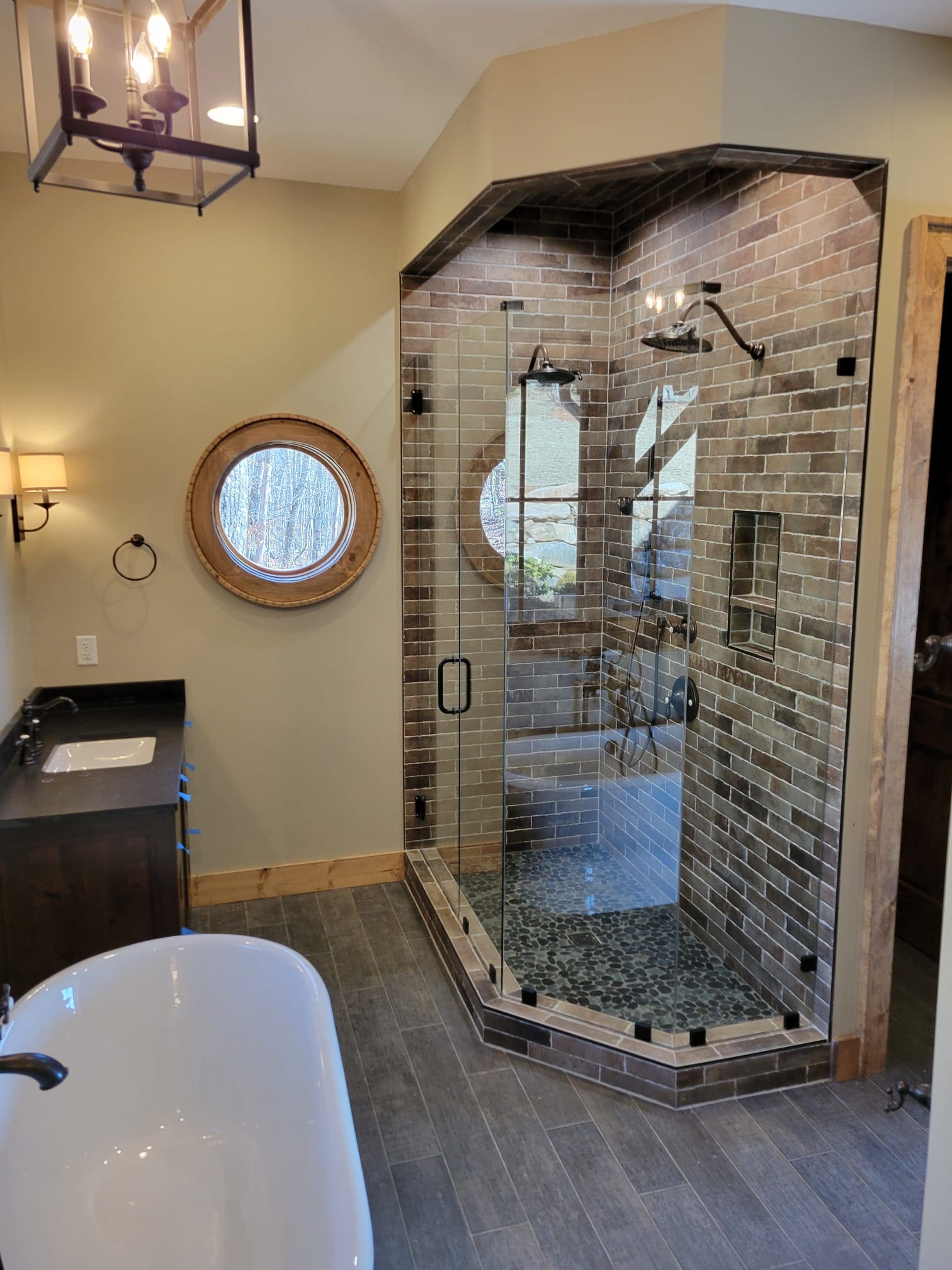 A bathroom with a large walk in shower and a tub.