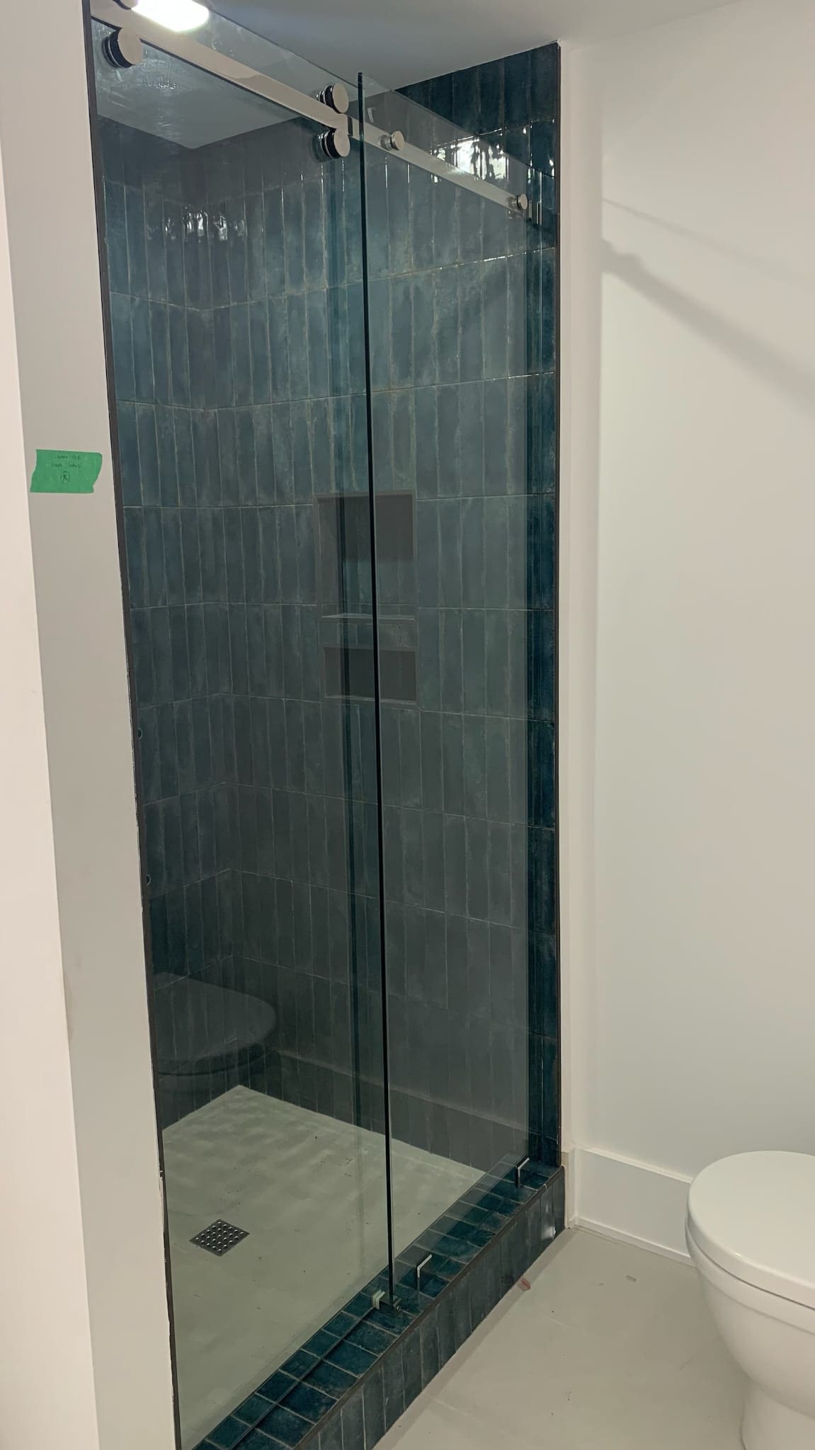 A bathroom with a shower and tiled walls.