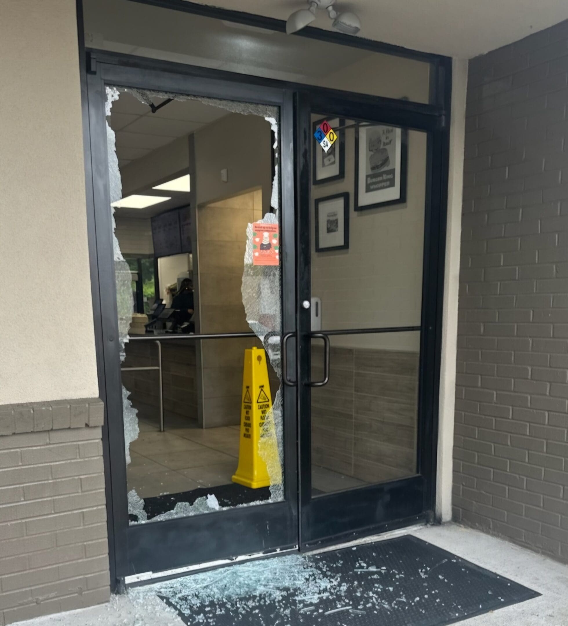 A broken glass door in the middle of a building.