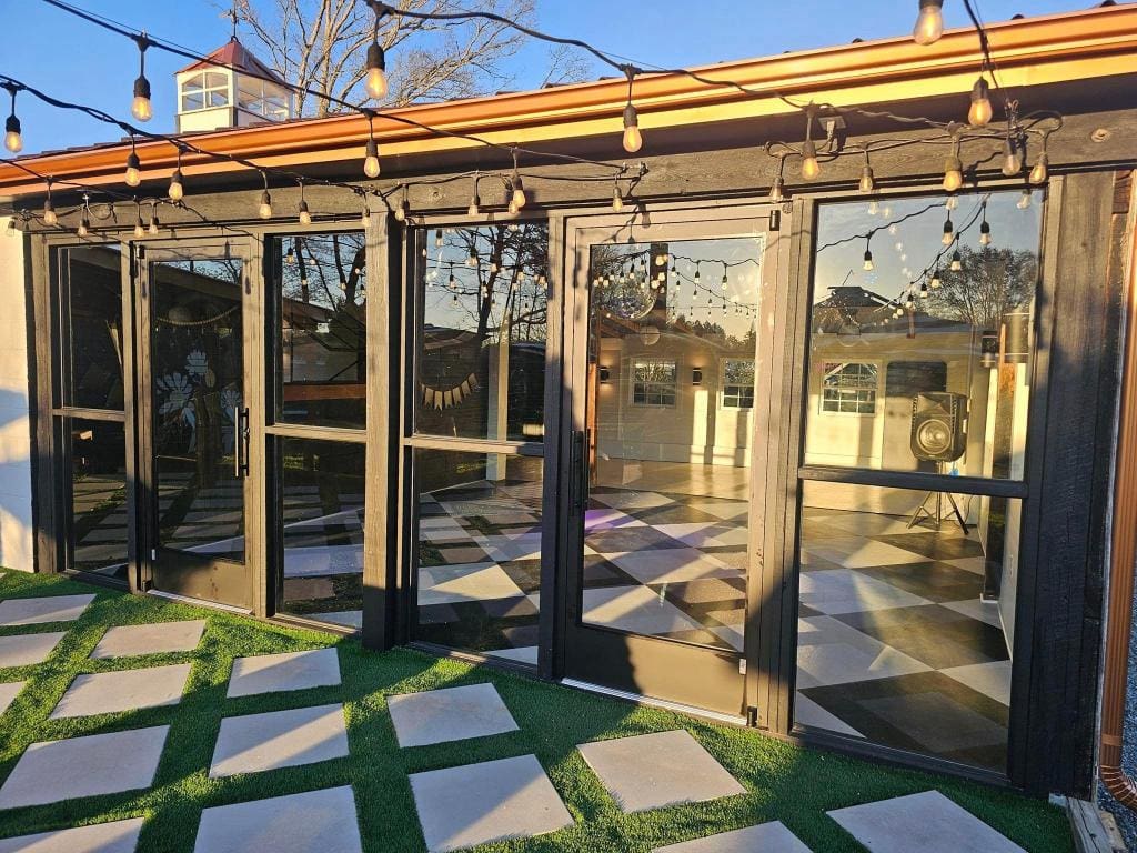 A patio with grass and glass doors