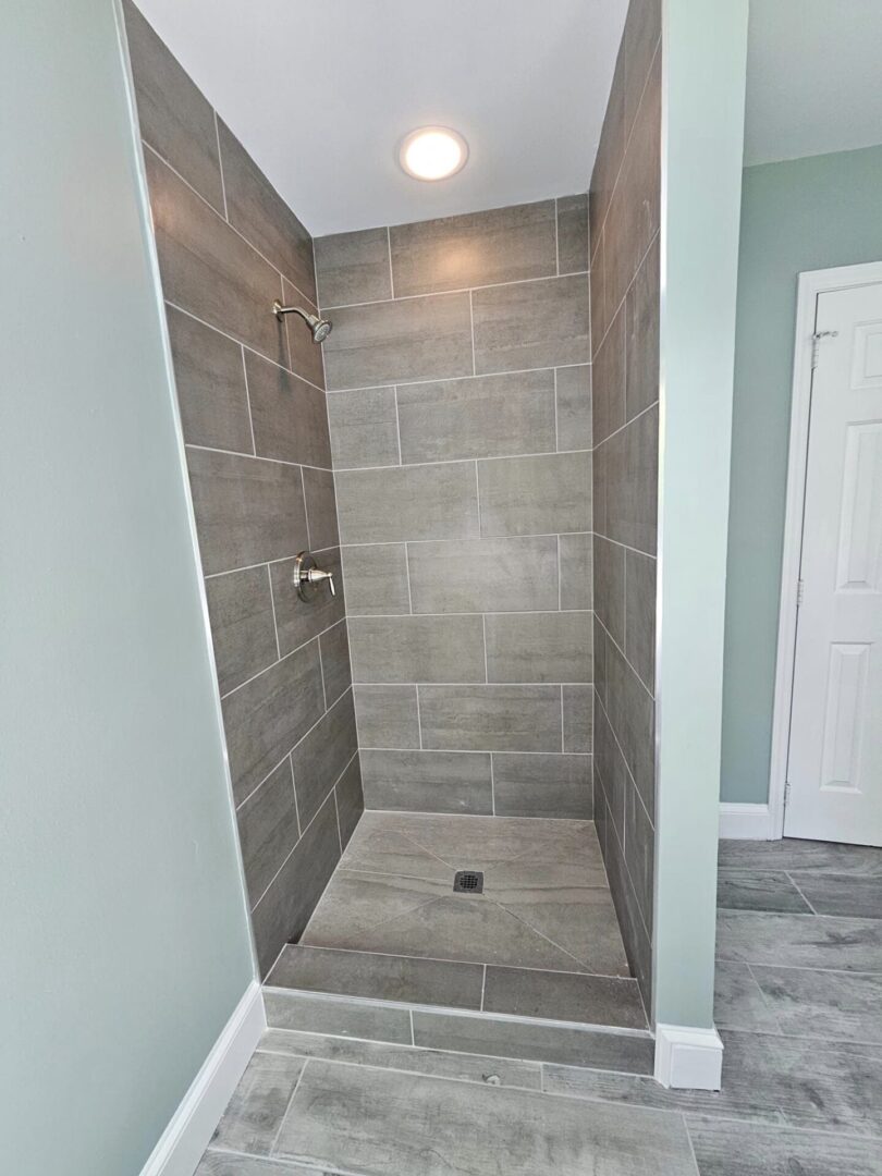 A bathroom with a walk in shower and tiled walls.